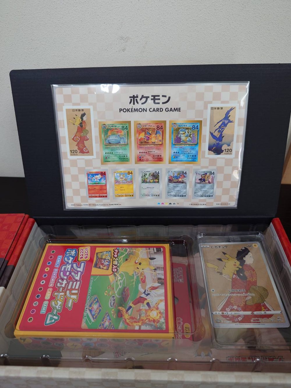 ポケモン切手BOXを開けたところ。切手シートとファミリーポケモンカードゲーム、ピカチュウのプロモカード